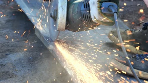 Worker Using Angle Grinder Cutting Metal with Sparks Flying in Moscow