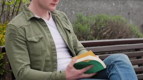 Männlicher Leser, der draußen in ein gutes Buch eintaucht