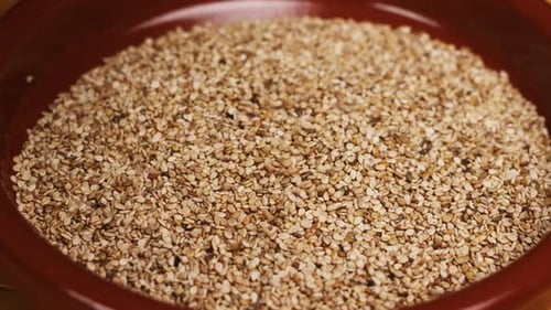 Sesame Seeds Filling a Brown Clay Bowl