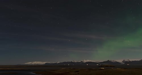time lapse of northern lights in iceland with mountains on background