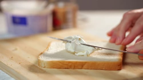 Spreading Cream Cheese on Bread Slice with Knife