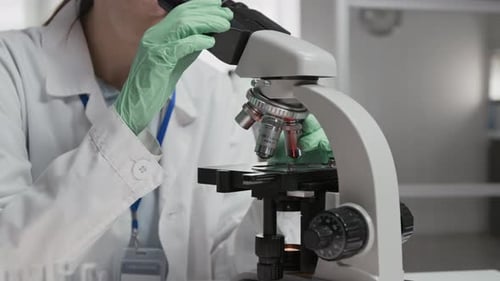 Close-up of Female Scientist Using Microscope While Working in Laboratory