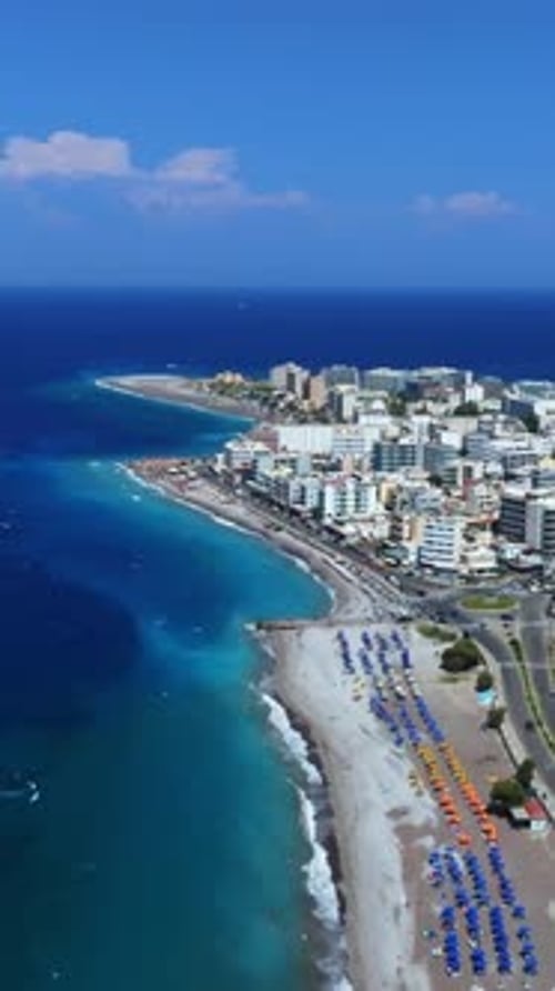 Vertical drone shot of beaches on the coastline of Rhodes city, in sunny Greece