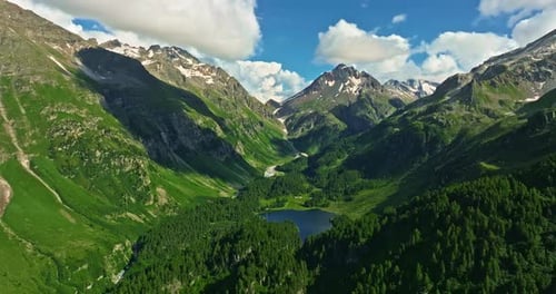 Drone Flies Over Green Picturesque Valley with Mountains in the Background High Mountains Famous