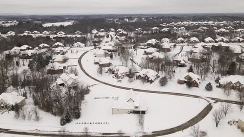 4K Aerial Flyover of Snow Covered Neighborhood with Houses and Trees