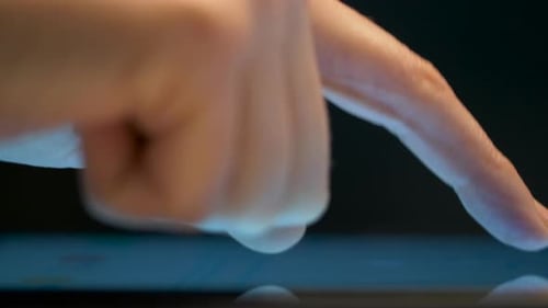 Young businesswoman's hand touches computer touchscreen in modern office
