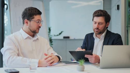 Businessmen Discussing Project in Modern Office