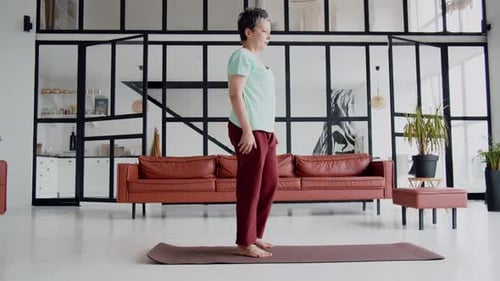 Senior Woman Practicing Yoga on Mat in Home