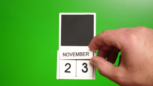 Hand Adjusting Block Calendar to November Twenty-Third