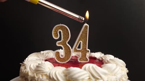 34. A candle in the form of the number 34, inserted into the holiday cake, is lit. Celebrating a bir