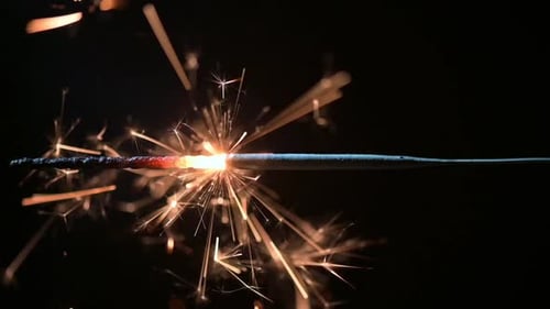 Sparkler burning brightly in dark celebration close up