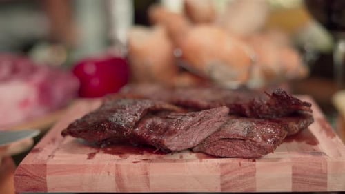 Close-up still shot of some cuts of juicy freshly roasted meat on a wooden board
