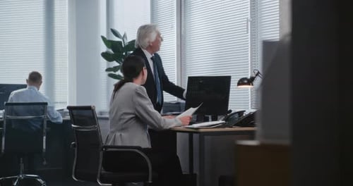 Man Discussing Documents With Woman in Office
