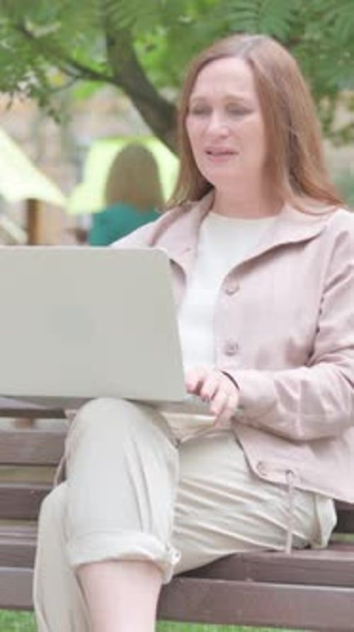 Modern Old Woman Facing Online Loss on Laptop Outdoor, vertical video