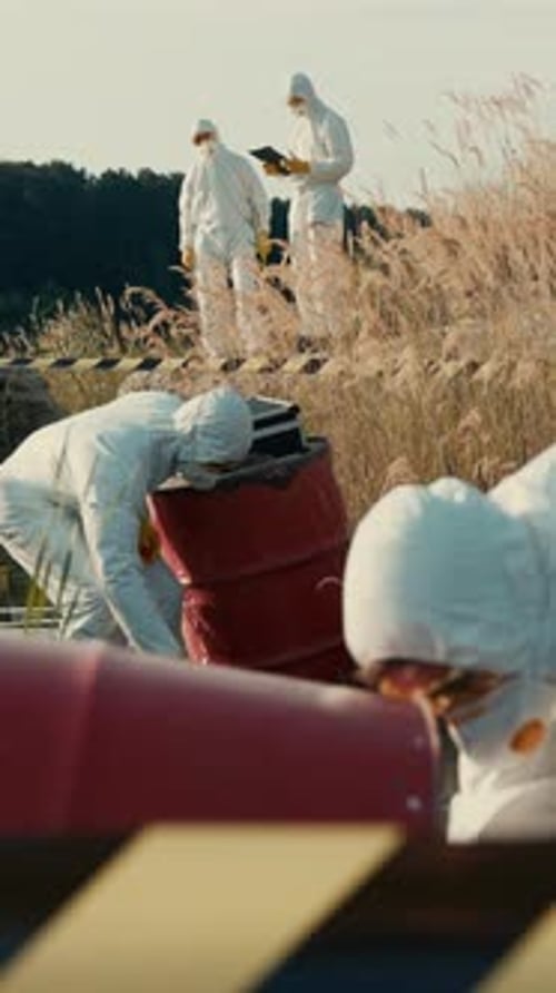 Team in Hazmat Suits Inspecting Toxic Waste Barrels