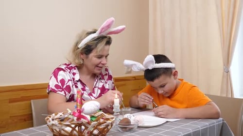 1. Mutter und Sohn feiern Ostern. Sie bereiten einen Korb vor, malen Eier und haben Spaß.