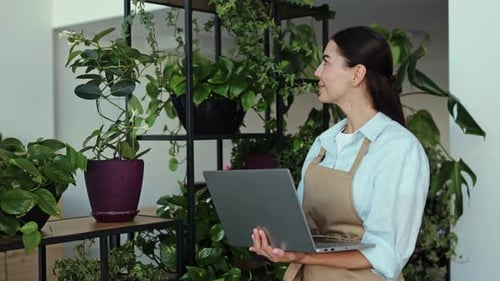 Woman Working at a Small Business Plant Shop on Laptop