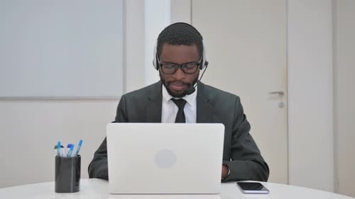 Man in Suit Working at Laptop with Headset