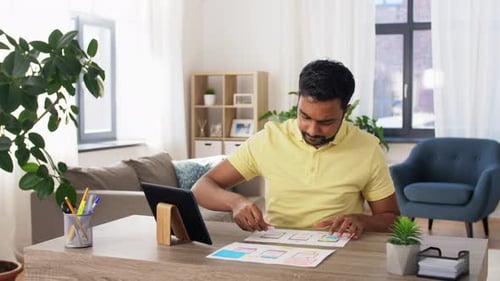 Man Designs Website Layout Using Tablet and Paper