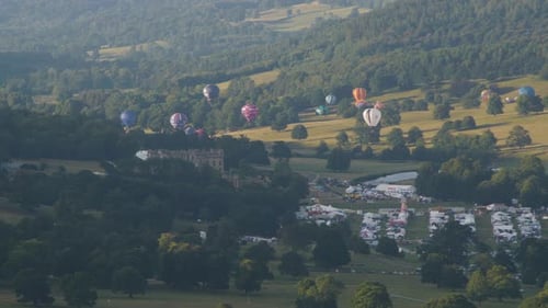 Hot Air Balloons Ascend over Countryside Festival