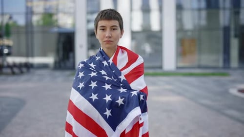Serious Caucasian Woman Proudly Representing Her Home Country and Putting USA Flag on Her Back