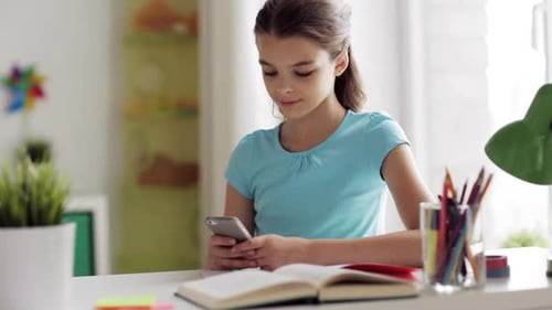 Girl Using Phone at Desk Indoors