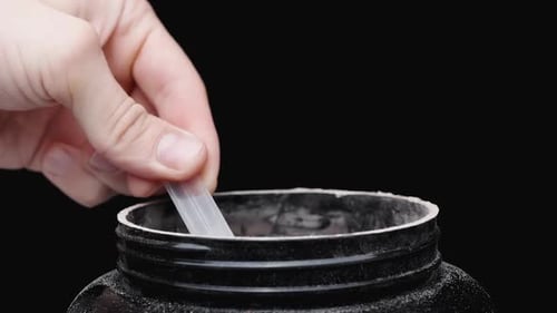 Protein Powder Poured into Black Container