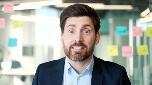 Webcam view. Angry dissatisfied businessman in a formal suit arguing on a video call looking