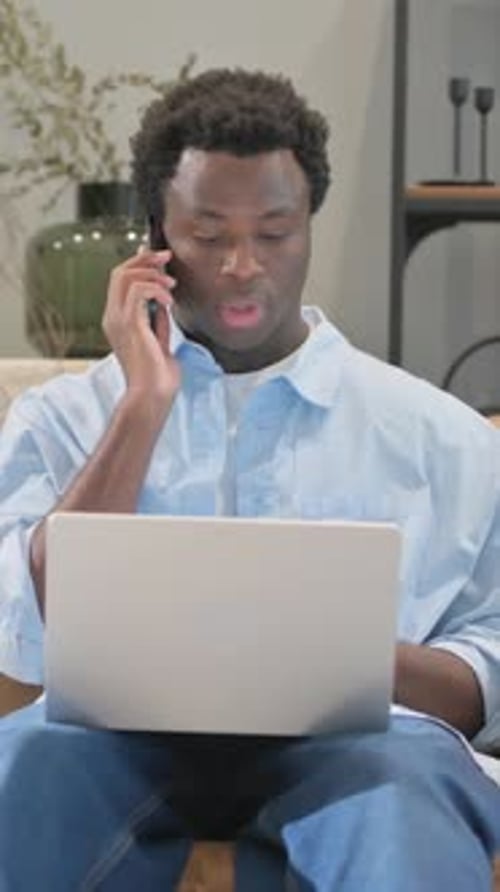 Adult Uses Laptop and Mobile Phone Indoors