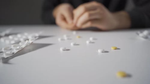 Close Up of Pills Being Handled at Table