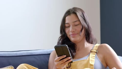 Young Woman Using a Smartphone and Credit Card for Online Shopping at Home