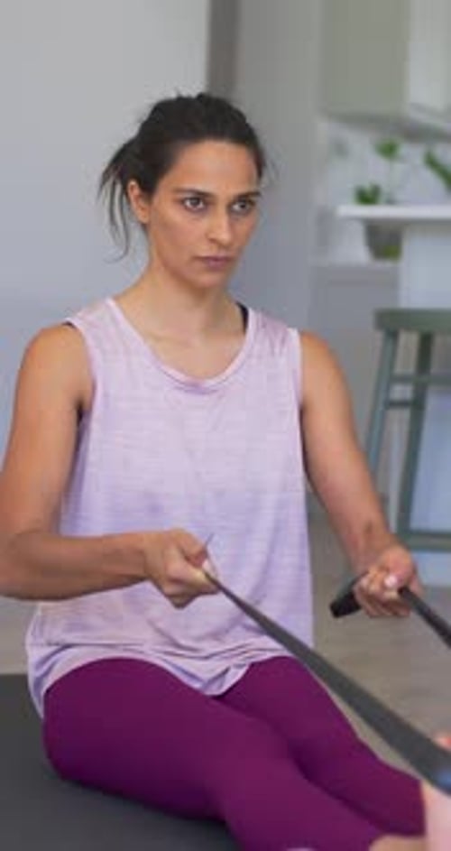 Mulher fazendo fileiras de faixas, faixa de ancoragem para os pés, estendendo, puxando com a câmera, aproximando-se dos ombros