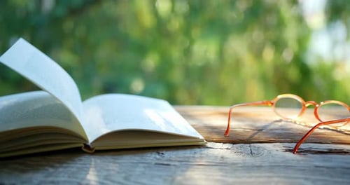 Open Book and Glasses on a Rustic Table