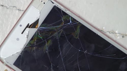 Close Up On A Smashed White and Pink Smartphone On The Floor