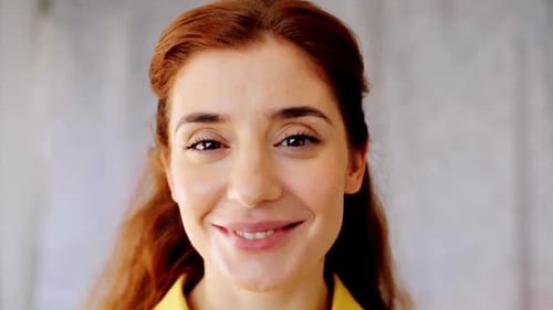 Woman smiling, looking directly at camera in close-up