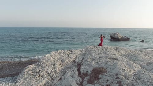 Violinist Playing Beautifully on Rocky Coastline