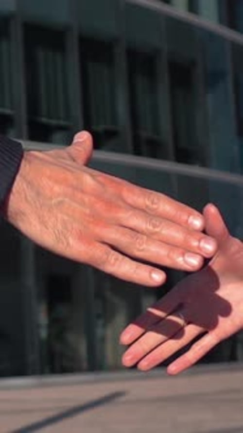 Man and Woman Shaking Hands in a City