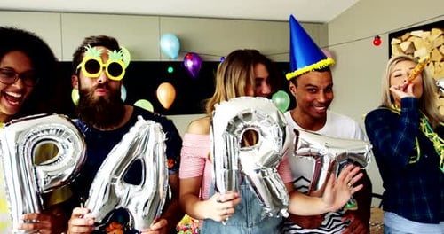 Friends Holding Party Balloons Celebrate a Birthday Indoors