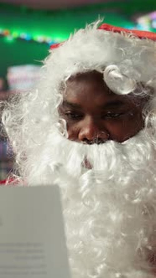 Vertical Video Father Christmas Reading Letters and Lists in His Festive Workshop