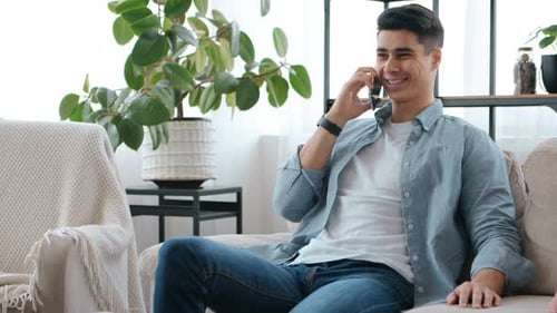 Smiling Young Man Chatting on Phone at Home