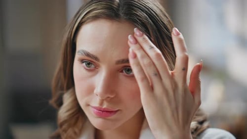 Woman Applying Moisturizer to Face Indoors