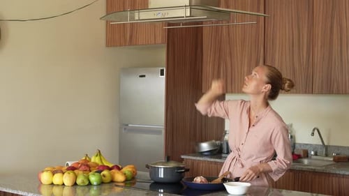 Woman Cooking Food in a Kitchen with Fruit