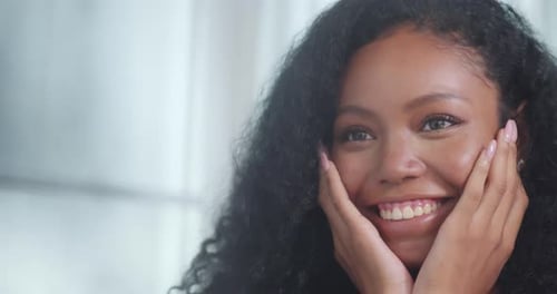 Beautiful Woman Smiling and Touching Her Face