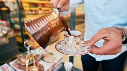 Close view of a barista pouring coffee into a traditional turkish cup in Istanbul, Turkey. Slow moti