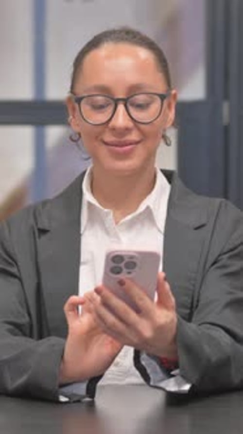 Mixed Race Business Woman Text Messaging on Phone in Office, vertical video