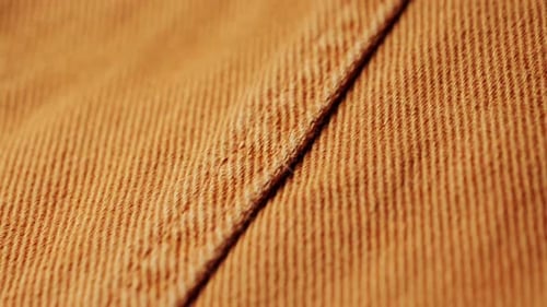 Brown denim fabric, seam on jeans close-up.