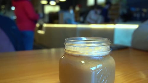 1-3 Histórico de bokeh em uma cafeteria com funcionários mascarados, as pessoas estão pedindo bebidas e na rua