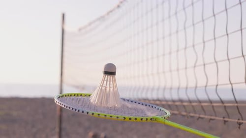 Nahaufnahme von Badminton- und Federballschlägern am Strand des Meeres