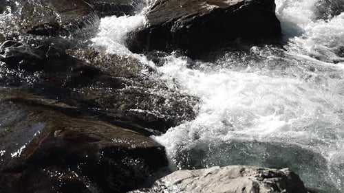 Rapid Flowing River Over Rocky Terrain in Nature. Slow Motion
