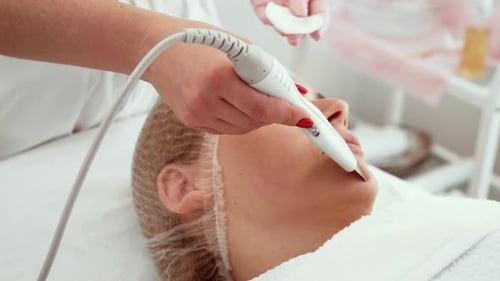 Beautician Using Ultrasonic Peeling Device for Skin Care Treatment in Dermatology Office Expert